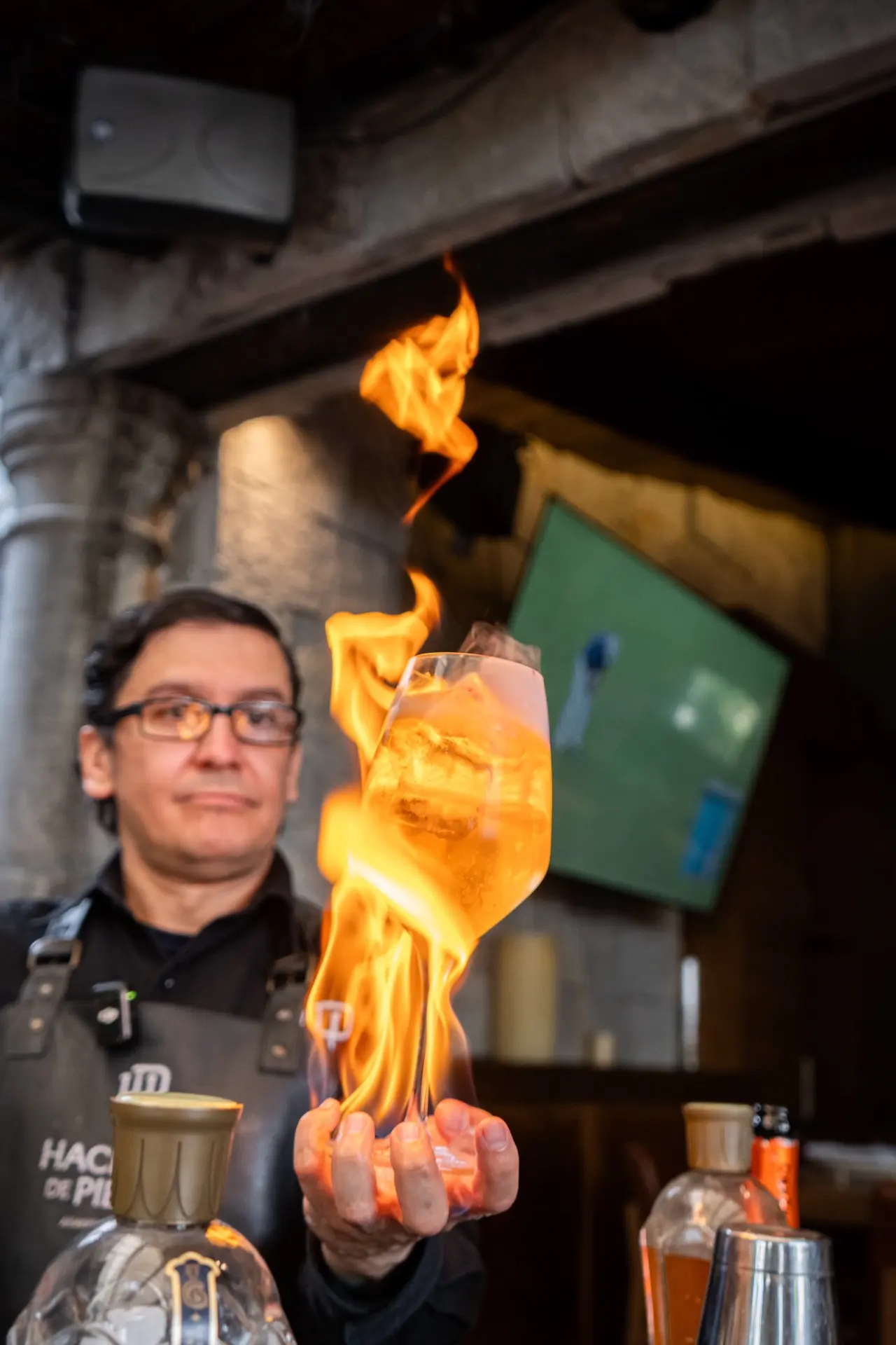 Bartender de Hacienda de Piedra flameando un coctel de autor en la barra