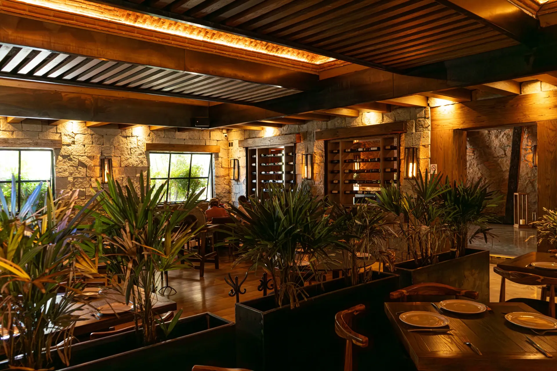 Interior del restaurante con arcos de piedra y vegetación