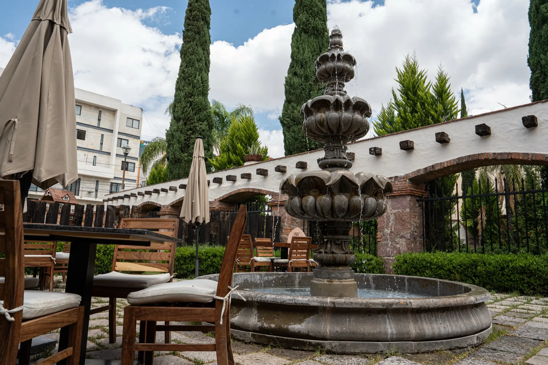 Patio de cantera de Hacienda de Piedra con fuente, sombrillas y jardín