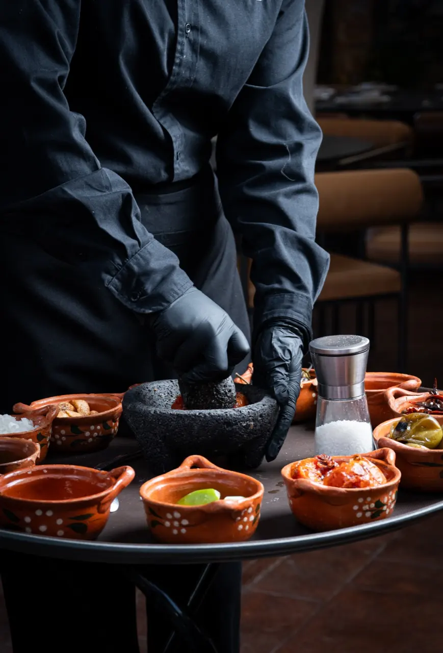 Preparaci&oacute;n de salsa en molcajete frente a la mesa, en Hacienda de Piedra